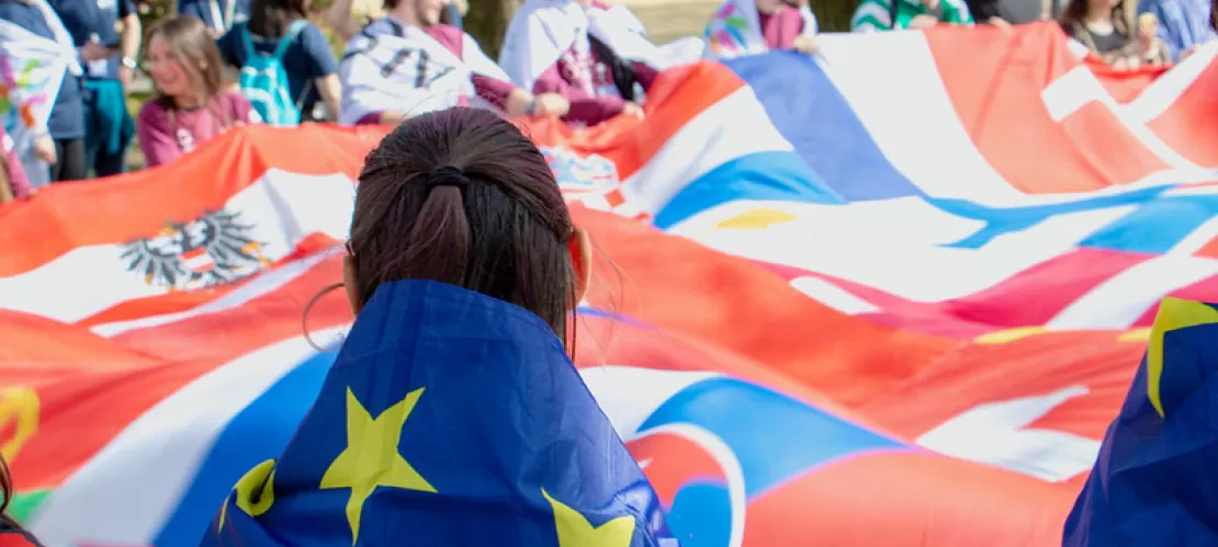 People gathering in a circle at a flag parade