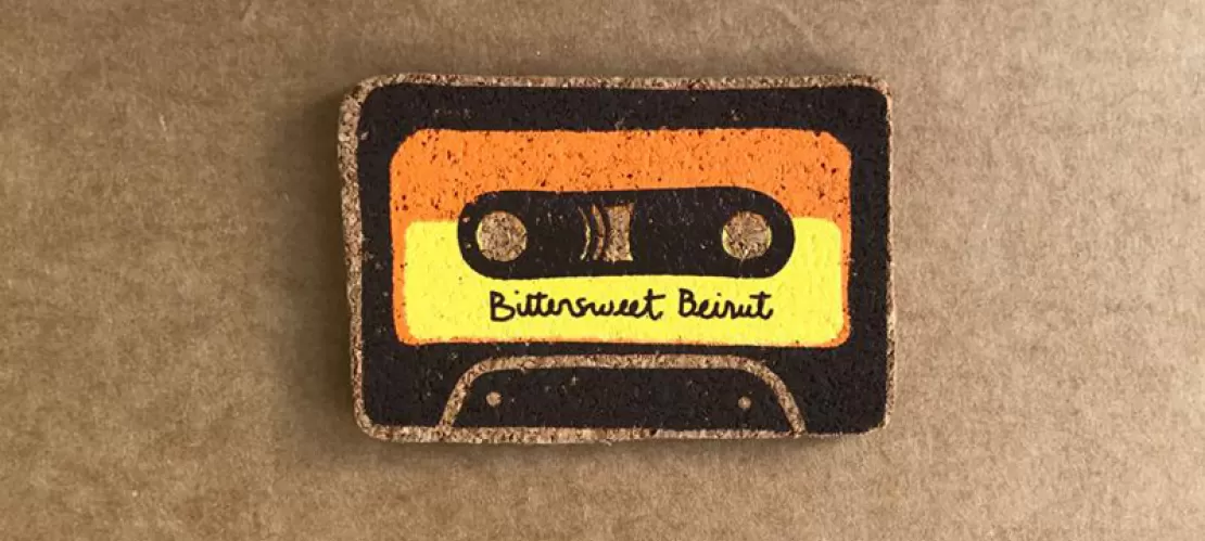 Magnet with the image of a black, orange and yellow cassette tape with the phrase "Bittersweet Beirut" in cursive font.