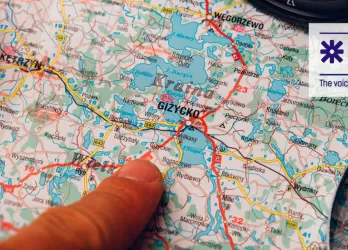 finger pointing a city on a map