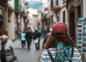 A girl standing in a street with her backpack