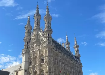 Leuven’s historic city center under a bright blue sky.
