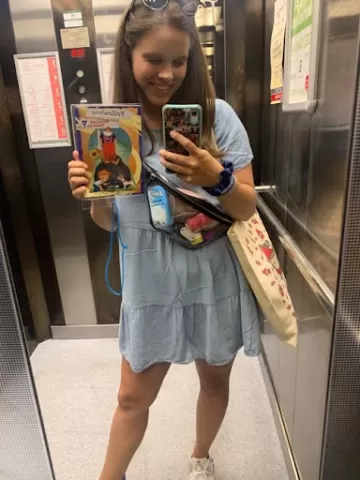 A selfie of Blanka in a mirror with a book in her hand