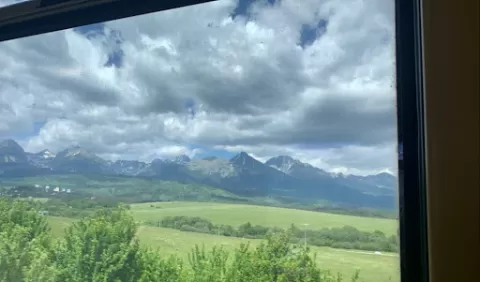 View from a train window: fields and mountains