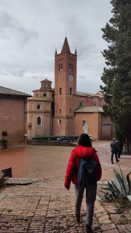 A monastery with a person wearing red jacket in front of it