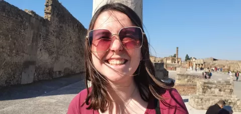 A girl smiling in front of an ancient city