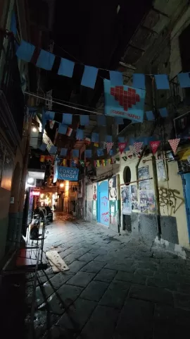A dark street with flags and Forza Napoli signs
