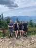 A group of four people with mountain view behind them
